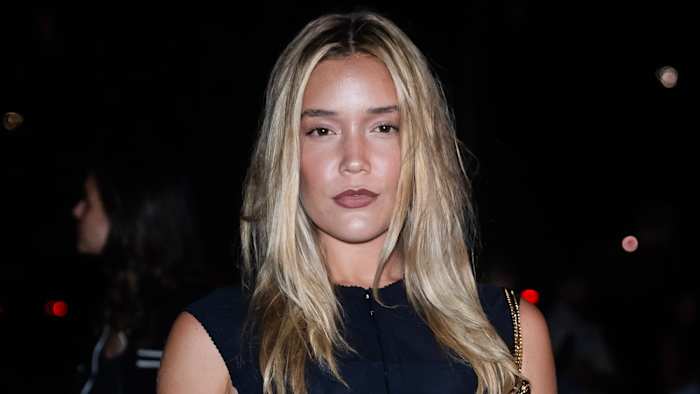 Olivia Ponton poses for the camera in a high-neck black top and a muted pink lip.